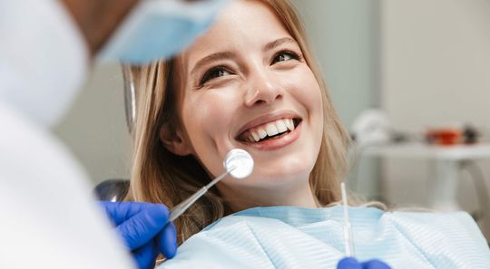 Junge Frau lächelt beim Zahnarzt